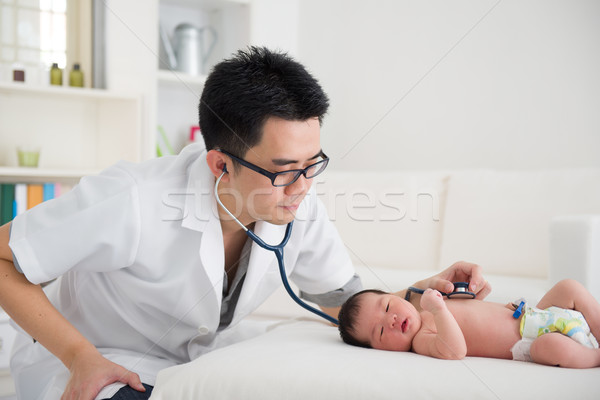 Good looking asian doctor and newborn baby on the clinic Stock photo © yuliang11