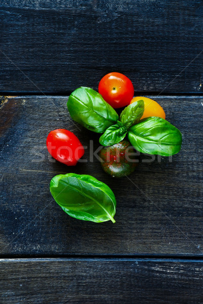 Colorido tomates cereja fresco manjericão folhas rústico Foto stock © YuliyaGontar