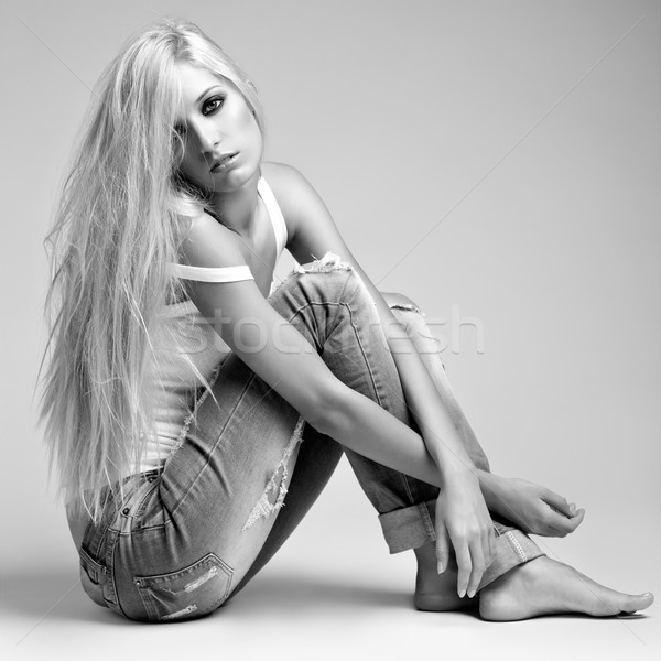 Stock photo: Blonde woman in ragged jeans and vest