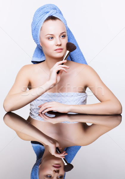 woman in blue bath towel on head with makeup brush Stock photo © zastavkin