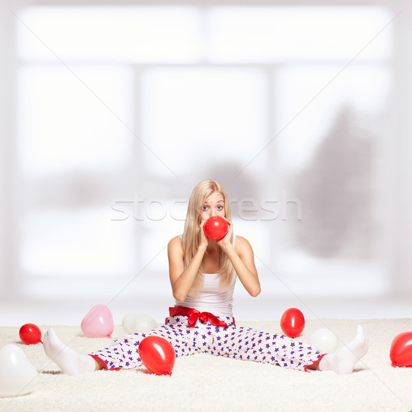 Blonde woman inflating balloons Stock photo © zastavkin