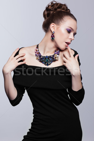 Jonge vrouw bijouterie grijs zwarte jurk hand gezicht Stockfoto © zastavkin