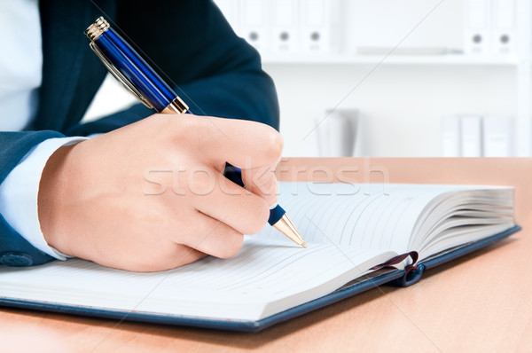 Cropped image of hand of young woman taking notes Stock photo © zeffss