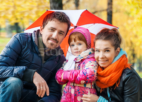 Happy young family under an umbrella in an autumn park Stock photo © zeffss