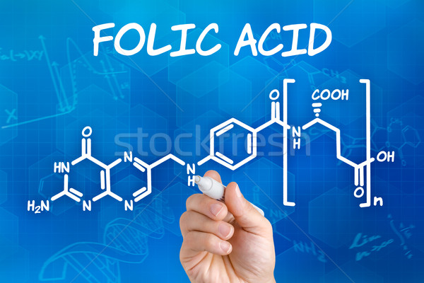 Hand with pen drawing the chemical formula of folic acid Stock photo © Zerbor