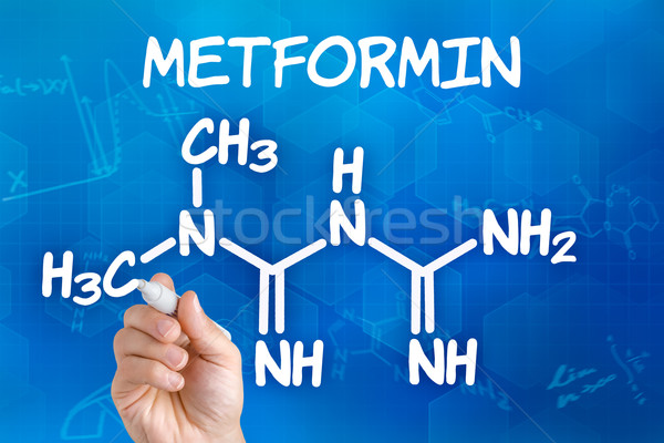 Hand with pen drawing the chemical formula of metformin Stock photo © Zerbor