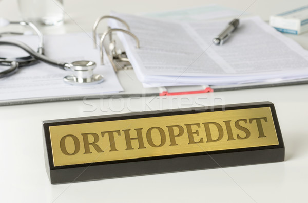 Name plate on a desk with the engraving Orthopedist Stock photo © Zerbor