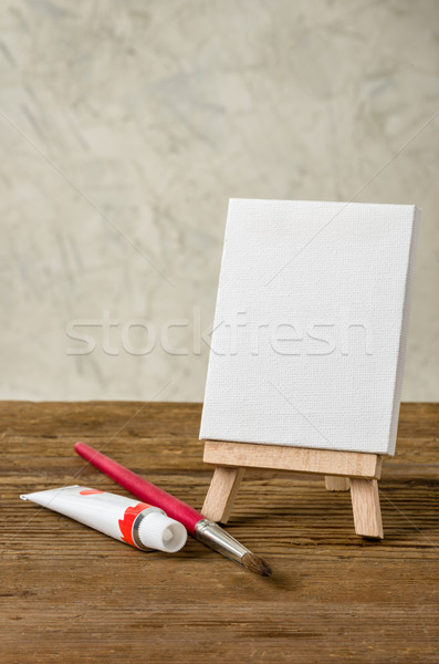 Stock photo: Easel with a blank canvas, paint and brush