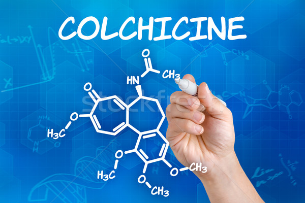Hand with pen drawing the chemical formula of colchicine Stock photo © Zerbor