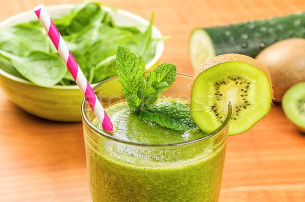 Green smoothie with a drinking straw and fresh ingredients Stock photo © Zerbor