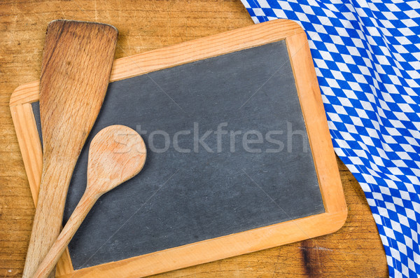 Wooden spoons and chalkboard with a bavarian tablecloth Stock photo © Zerbor