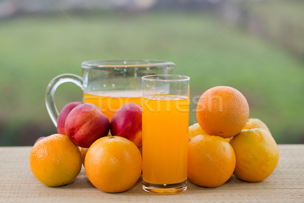 Foto stock: Suco · de · laranja · óculos · pêssegos · mesa · de · madeira · ao · ar · livre · céu