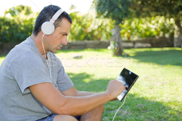Férfi megnyugtató táblagép fiatalember hallgat zene Stock fotó © zittto