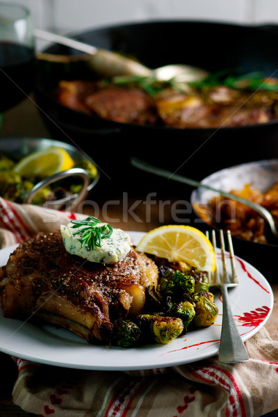 A SKILLET SEARED RIBEYE WITH HOMEMADE HERB BUTTER, CARAMELIZED ONIONS, AND FRIED BRUSSEL SPROUTS Stock photo © zoryanchik