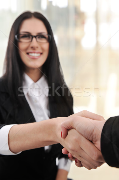 Business woman smiling and handshaking over white background Stock photo © zurijeta