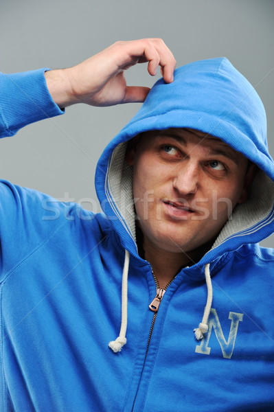 Young man in hooded sweatshirt scratching his head Stock photo © zurijeta