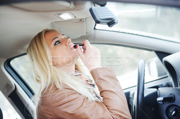 Girl putting on lipstick in car Stock photo © zurijeta