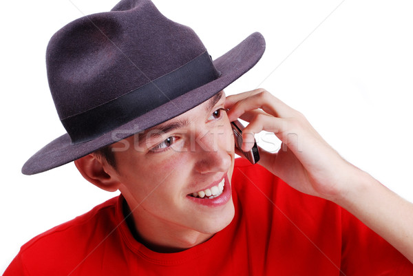 Young man with red shirt and black hat speaking on phone Stock photo © zurijeta