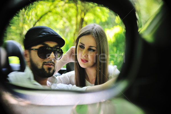 Stock photo: Young lovers in a side mirror of a car