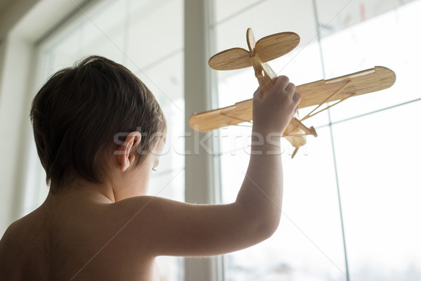 Happy little kid wants to fly with his airplane trough the windo Stock photo © zurijeta