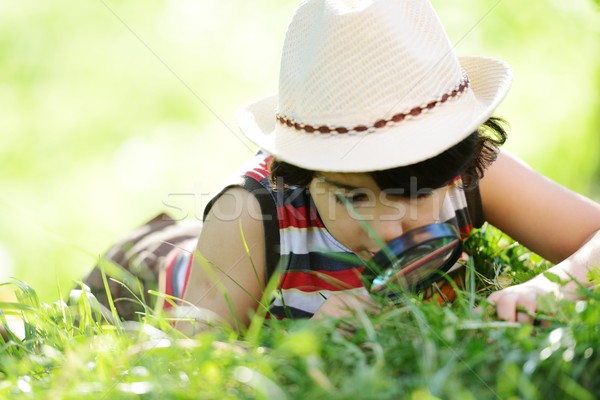 Happy kid exploring nature with magnifying glass Stock photo © zurijeta