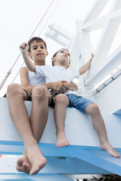 Cheerful little boy sitting on white bridge and enjoy Stock photo © zurijeta
