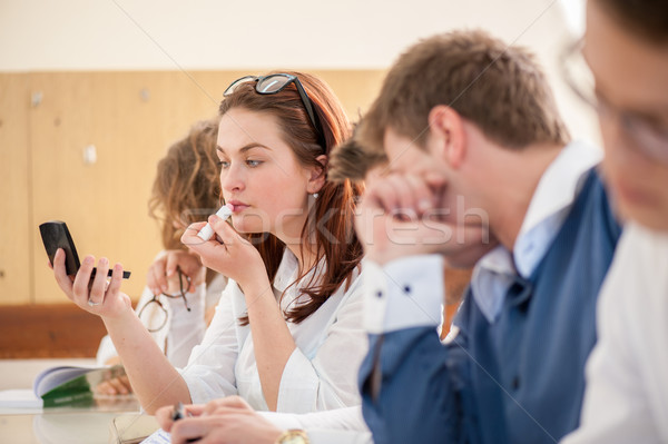 Schoolgirl putting a lipstick Stock photo © zurijeta