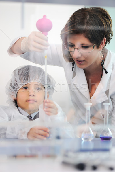 Smart cute little male child  experimenting in lab with his mother doctor scientist Stock photo © zurijeta