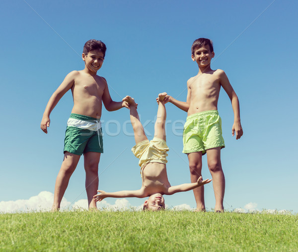 Brothers playing upside down on green meadow Stock photo © zurijeta