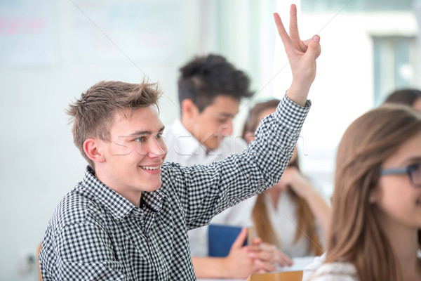 Smiling student raising hand Stock photo © zurijeta