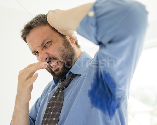Business man with sweating under armpit in blue shirt Stock photo © zurijeta