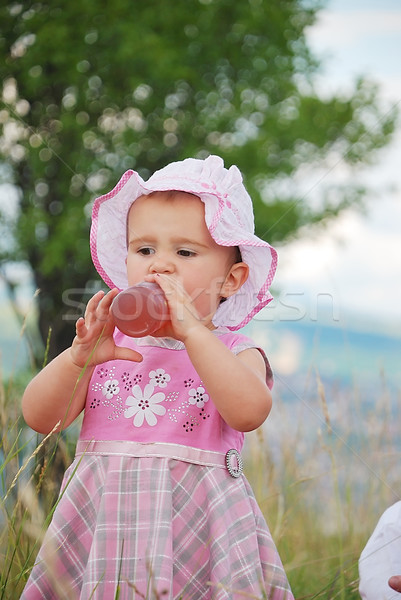 Kleines Mädchen trinken Flasche Freien Himmel Baby Stock foto © zurijeta
