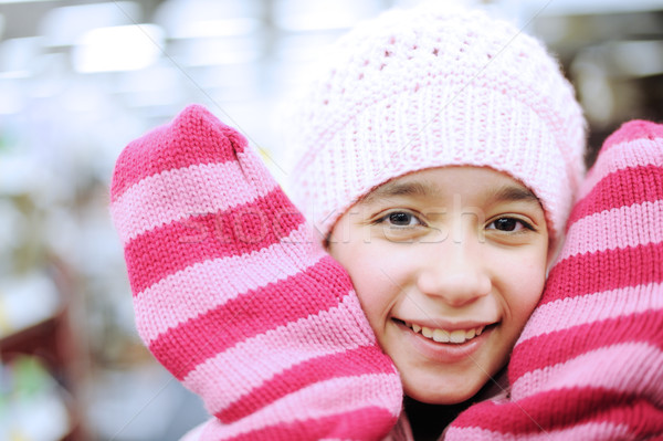Portrait of a beautiful smiling girl wearing winter hat and gloves Stock photo © zurijeta