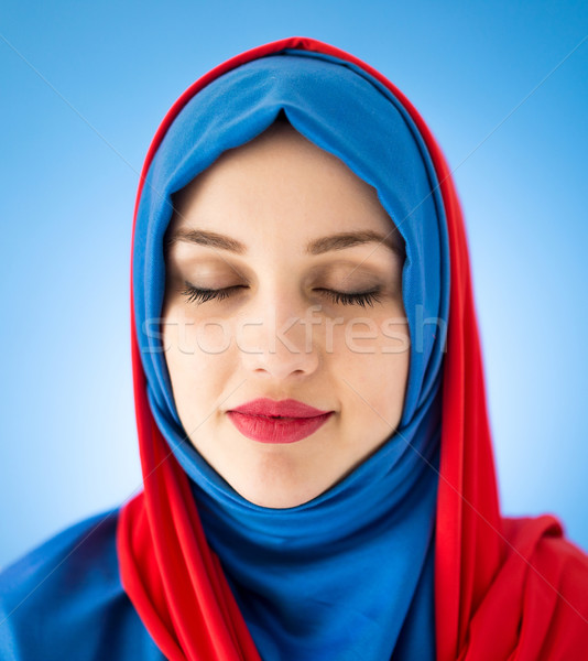 Beautiful Arabic girl with scarf over blue background Stock photo © zurijeta