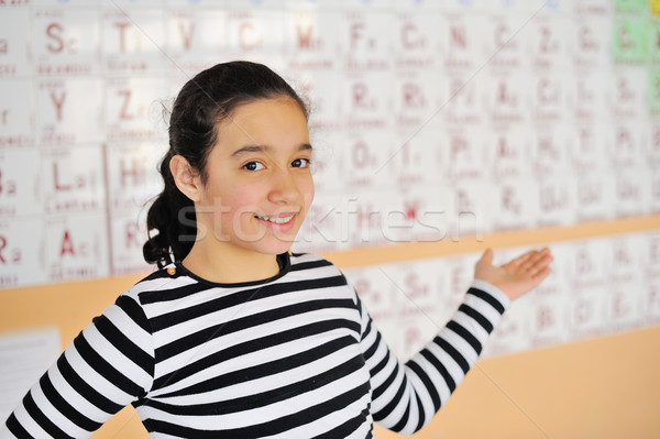 Beautiful girl standing in front of a periodic table of elements Stock photo © zurijeta