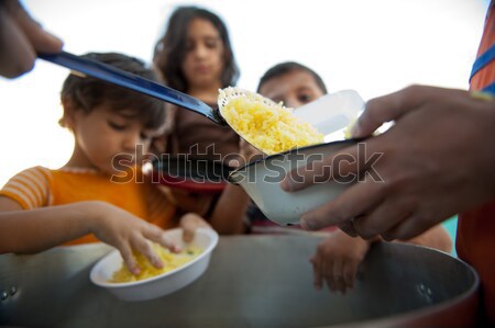 Stock photo: Hungry children in refugee camp, distribution of humanitarian food