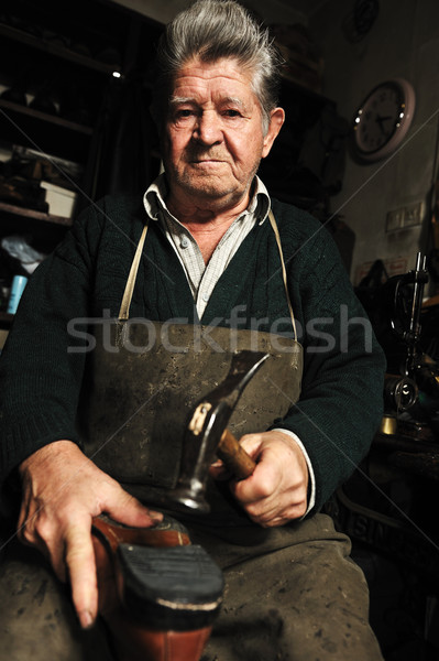 Elderly man, shoemaker repairing old shoe in his workshop Stock photo © zurijeta