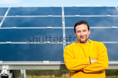 Young male engineer with solar panels in background Stock photo © zurijeta