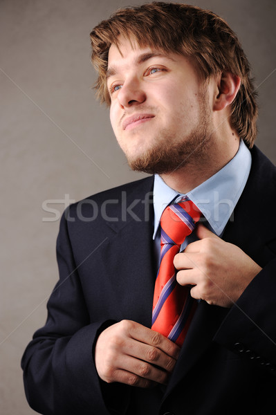 Young man with suit having problem with his tie Stock photo © zurijeta