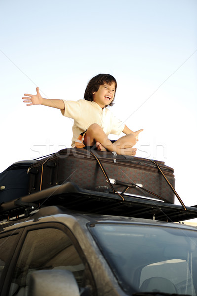 Little boy traveling on bags, the top of the car Stock photo © zurijeta