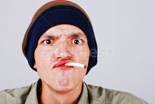 Funny face young man with cigarete in hand Stock photo © zurijeta