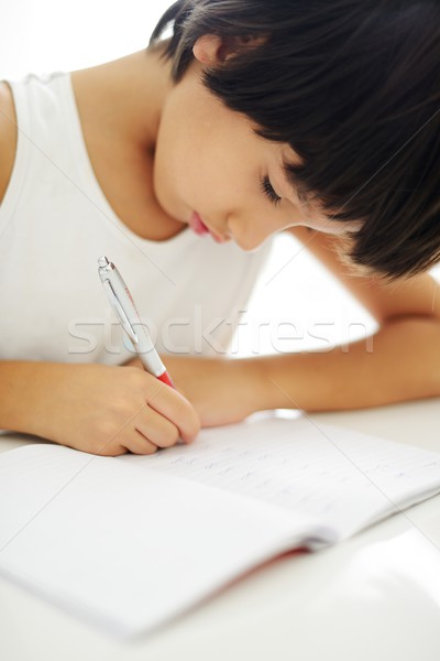 Boy writing on paper at his school Stock photo © zurijeta