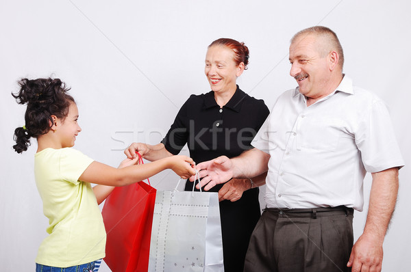 Cute girl is giving a present to her (grand)parents Stock photo © zurijeta