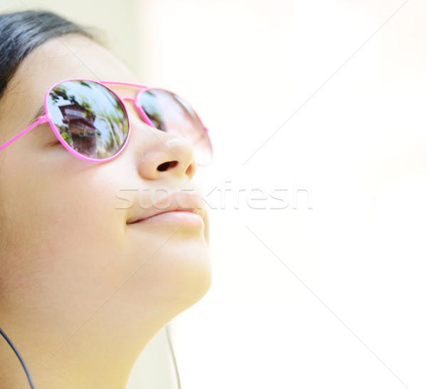 Stock photo: Beautiful teenage girl listening to music on headphones and enjo