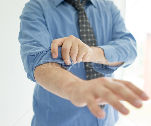 Stock photo: Businessman rolling his sleeves ready to work