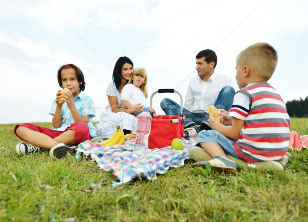 Stock photo: Family with children having picnic time on green meadow in natur