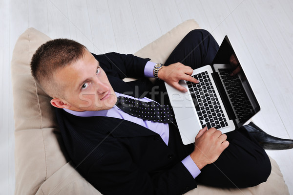 Top view of businessman sitting in comfortable armchair holding laptop Stock photo © zurijeta