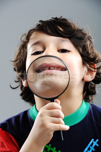 Portrait of child looking closely with magnifying glass Stock photo © zurijeta