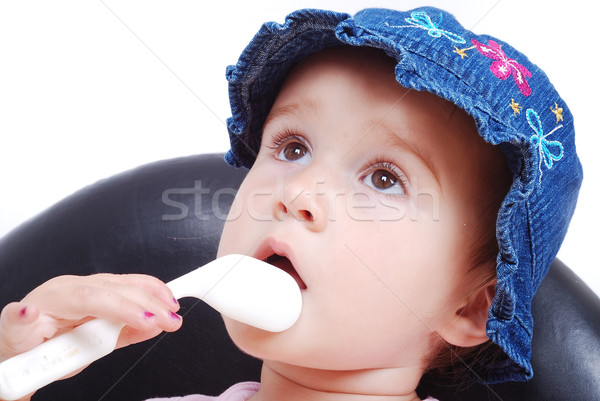 Baby sitting on the black chair and eating isolated Stock photo © zurijeta