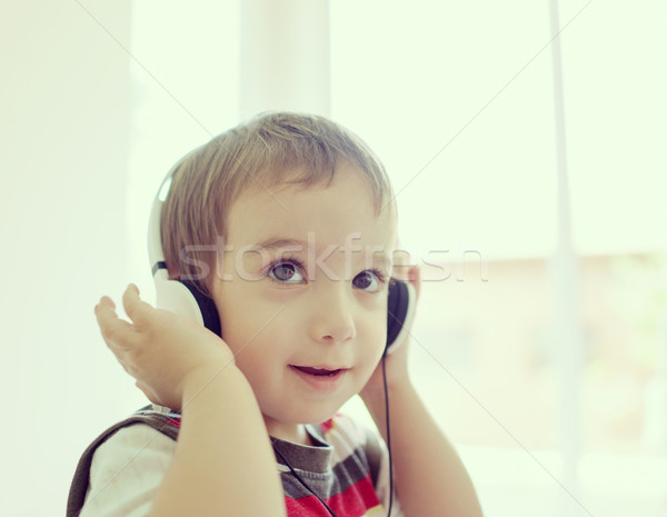 Adorable little boy at home listening to music with headset on h Stock photo © zurijeta